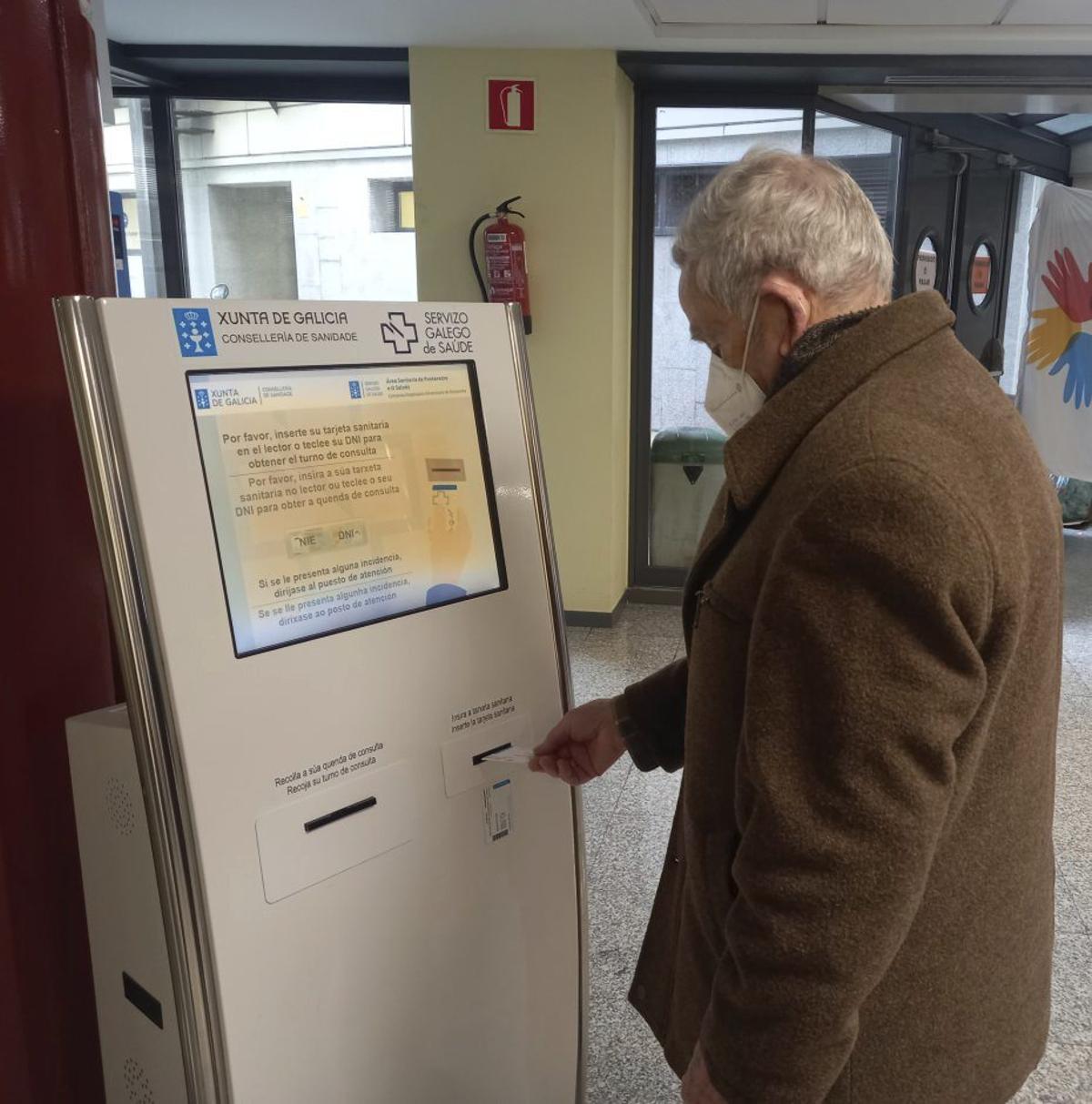 Un paciente mete su tarjeta sanitaria para su cita en Montecelo.