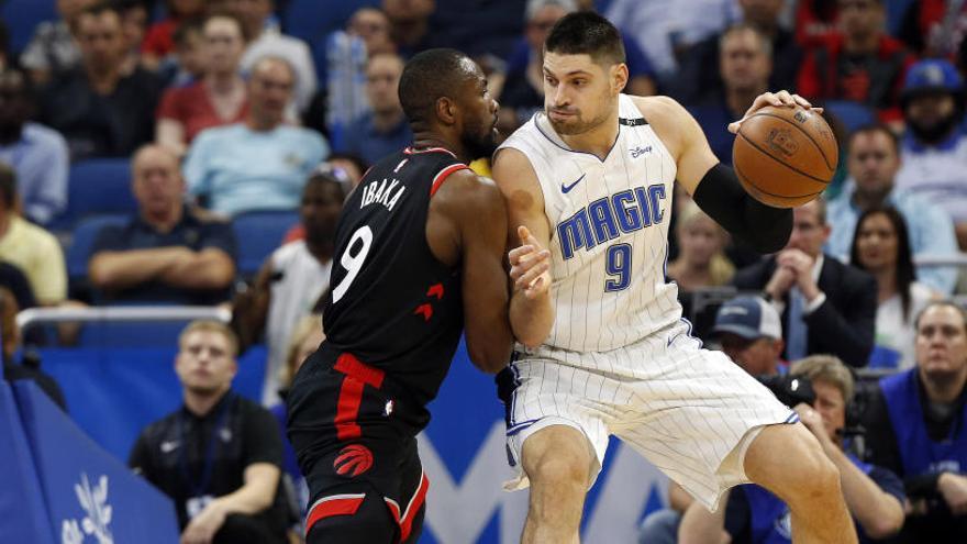 Nikola Vucevic (d) pelea  con Serge Ibaka por el balón.