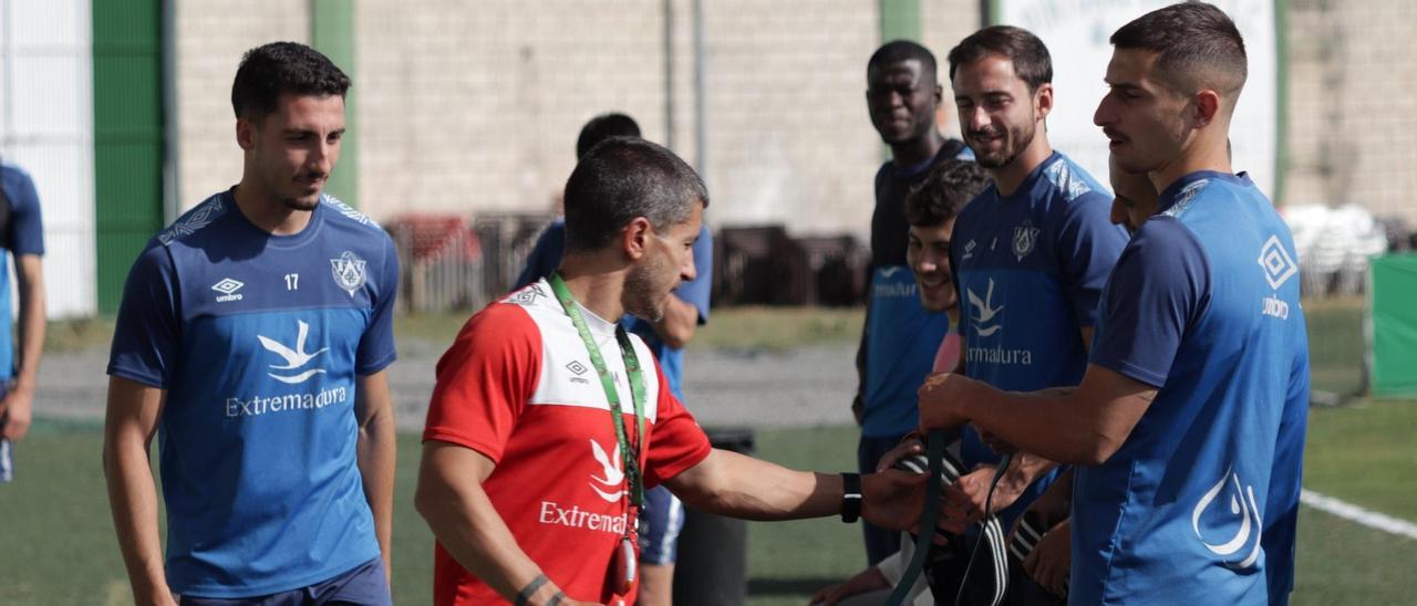 Alberto Muñoz (de rojo), preparador físico del Cacereño, da instrucciones a los jugadores durante un entrenamiento de esta semana.