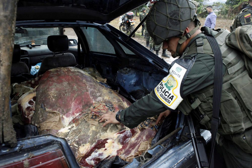 A Colombian policeman inspects meat seized in a ...