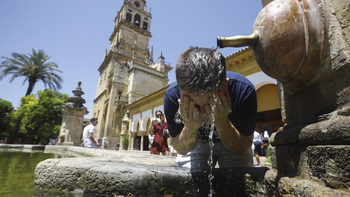 Un hombre se refresca en la fuente del Patio de los Naranjos, en Córdoba, este sábado, en una jornada de calor sofocante.