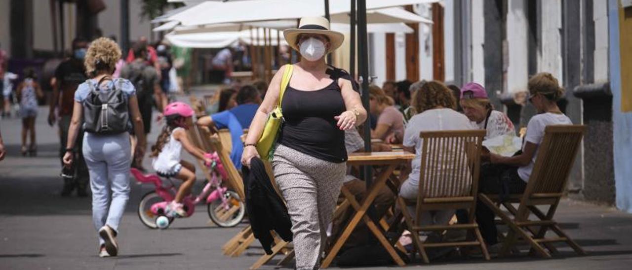 Una mujer pasea cerca de la terraza de un restaurante de La Laguna.