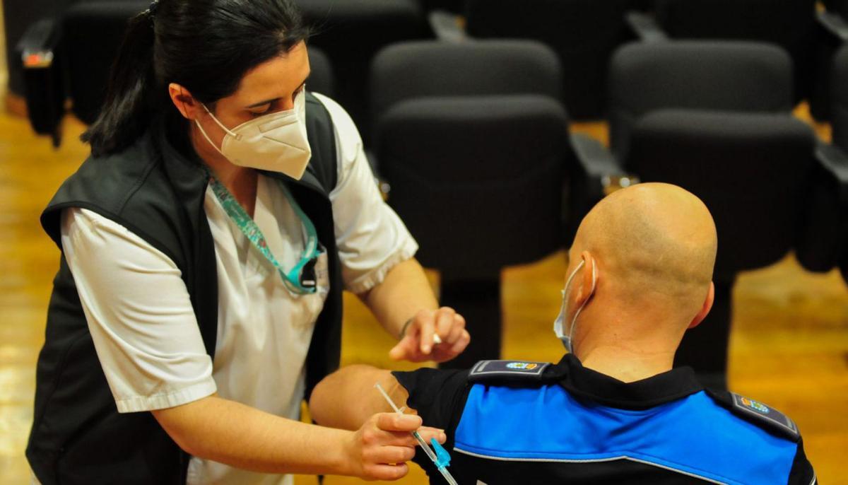 Una enfermera vacuna a un policía local en el Hospital do Salnés.   | // IÑAKI ABELLA