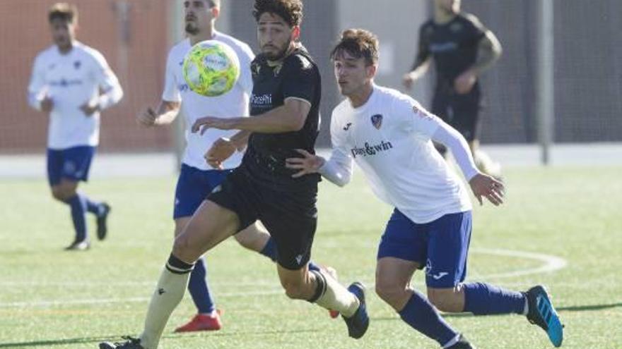 Paco Candela, que abrió la cuenta para el Intercity, presionado por dos rivales del Alzira.