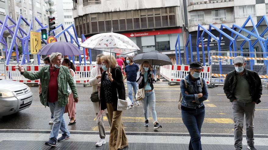Gente con paraguas bajo la lluvia en Vigo. // José Lores