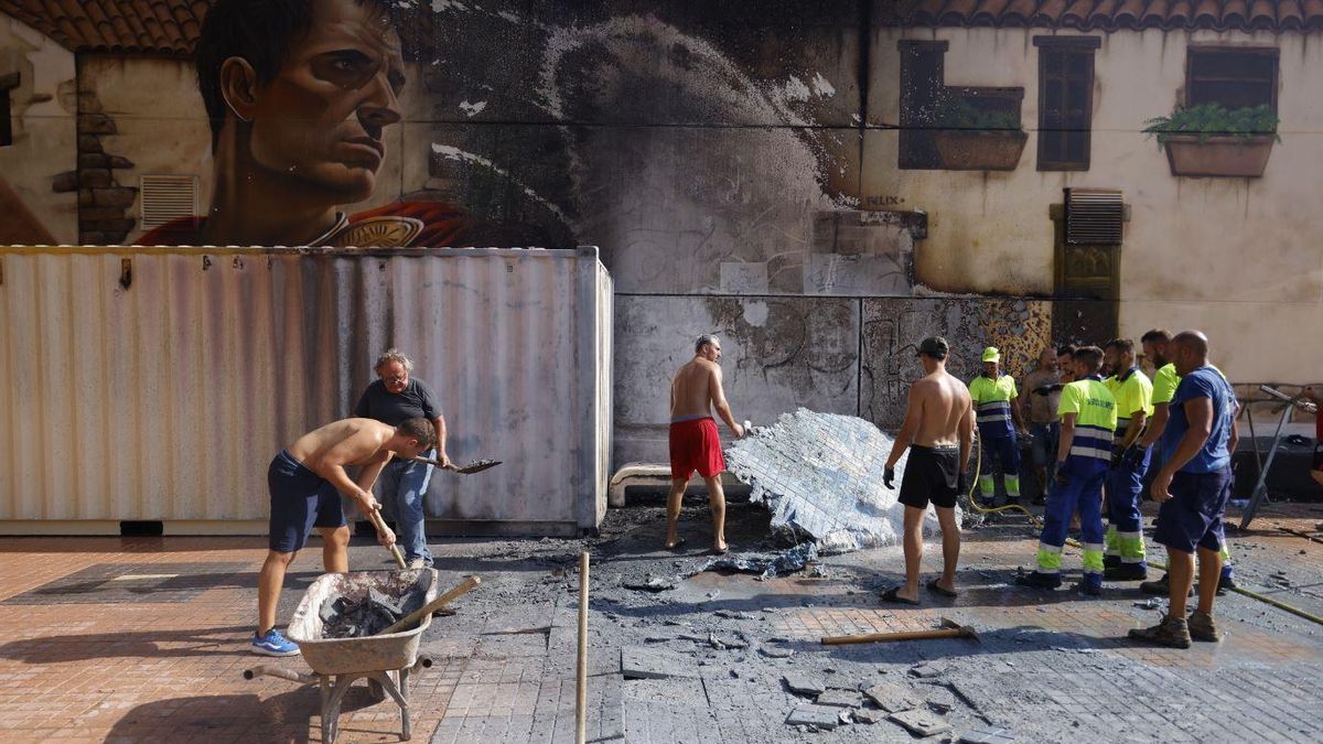 Una vez sofocadas las llamas, un grupo de hombres trabaja y observa los daños en el mural de Canteras.