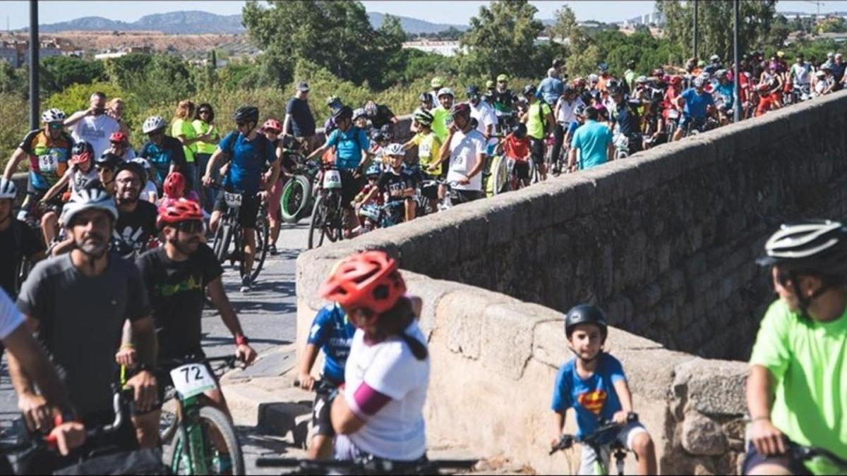 El pelotón del Día de la Bicicleta, a su paso por el Puente Romano de Mérida.