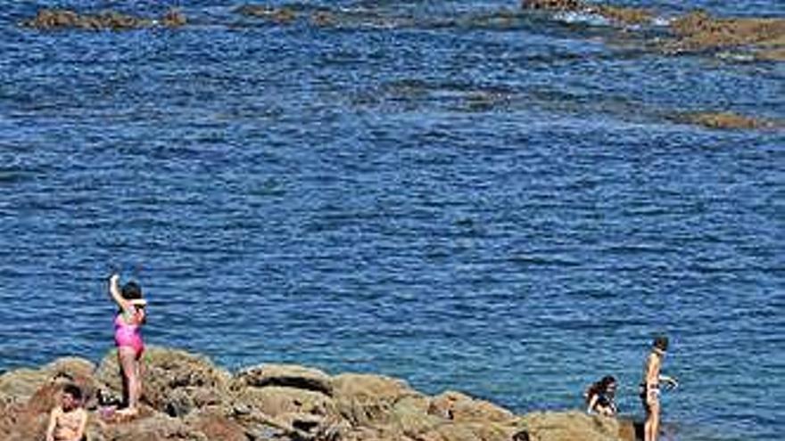 Bañistas en la orilla de la Playa de Riazor en A Coruña.