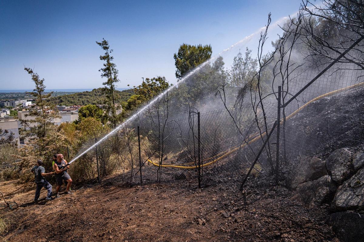 Vecinos de Gavà ayudan a apagar un incendio en su zona forestal.