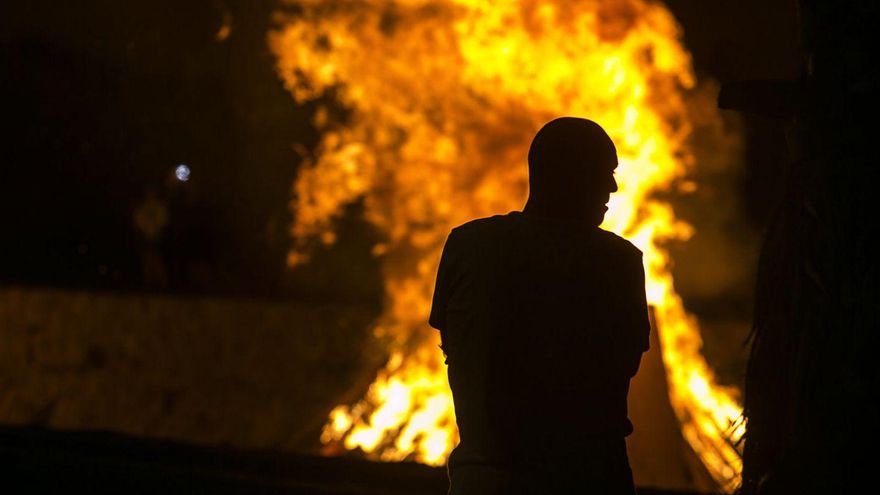 Una persona contempla el fuego de una hoguera la Noche de San Juan en un punto de Tenerife.