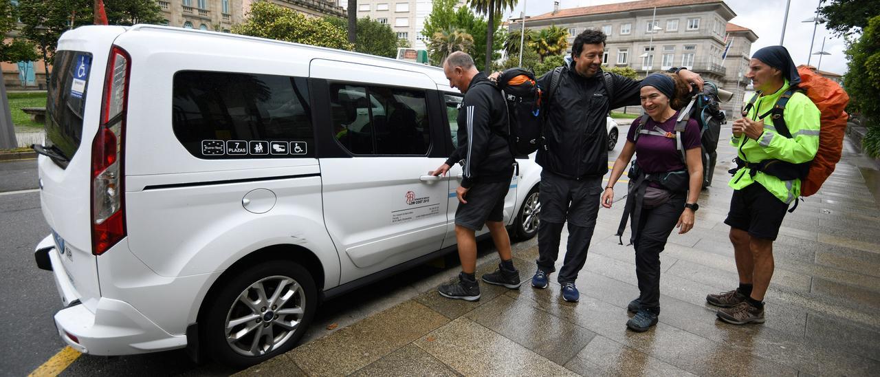 Un grupo de peregrinos se dispone a coger un taxi en la Alameda de Pontevedra.