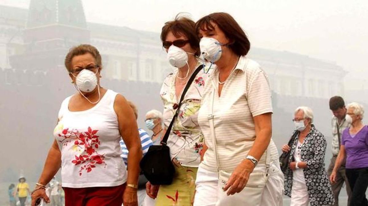 Un grup de turistes porten mascaretes per evitar respirar el fum procedent dels incendis.