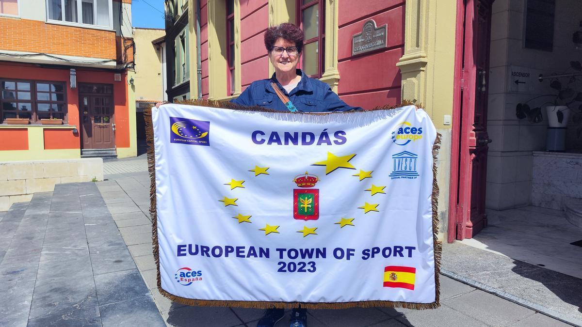 La olímpica Luisa Álvarez con la bandera que acredita a Candás como Villa Europea del Deporte. | A. G-O.