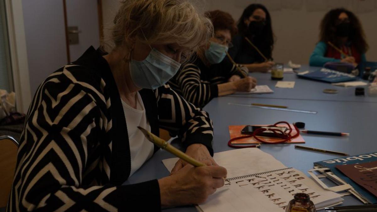 Una de las asistentes practica con una pluma de bambú. | J.L.F.