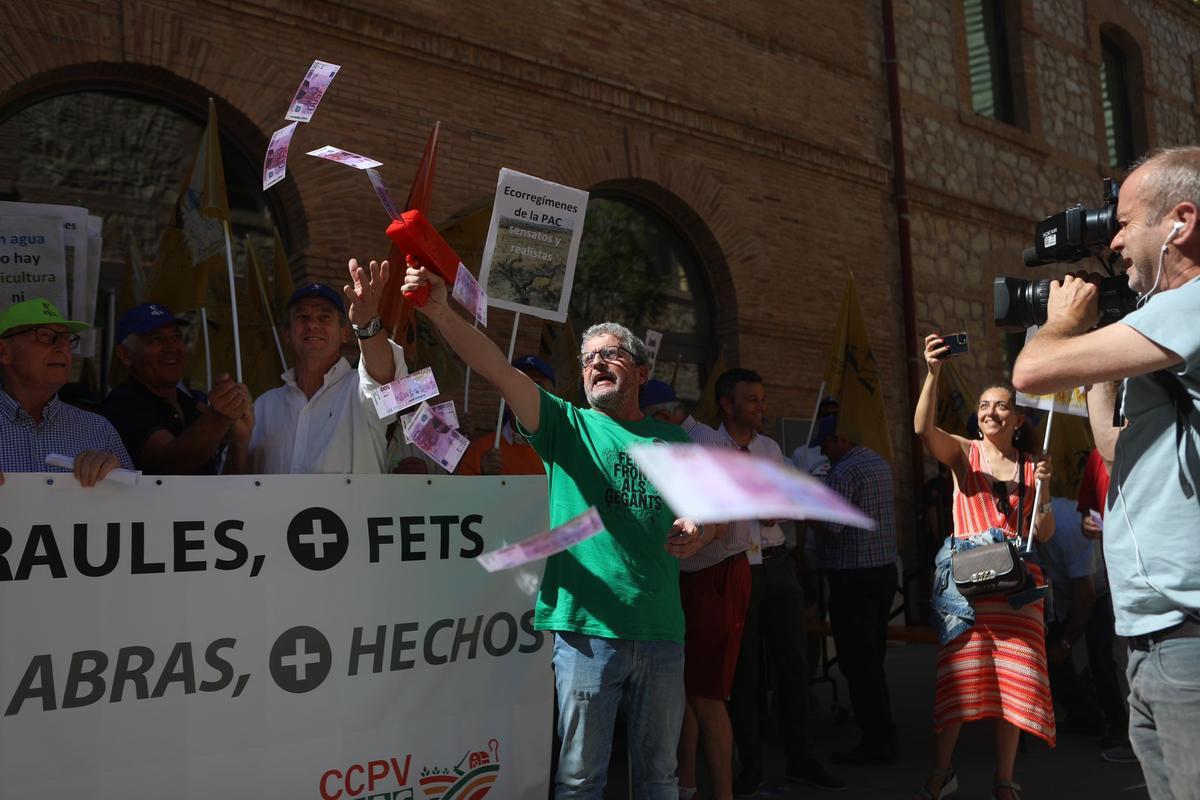 Un manifestante lanza billetes al aire frente a la conselleria de Agricultura