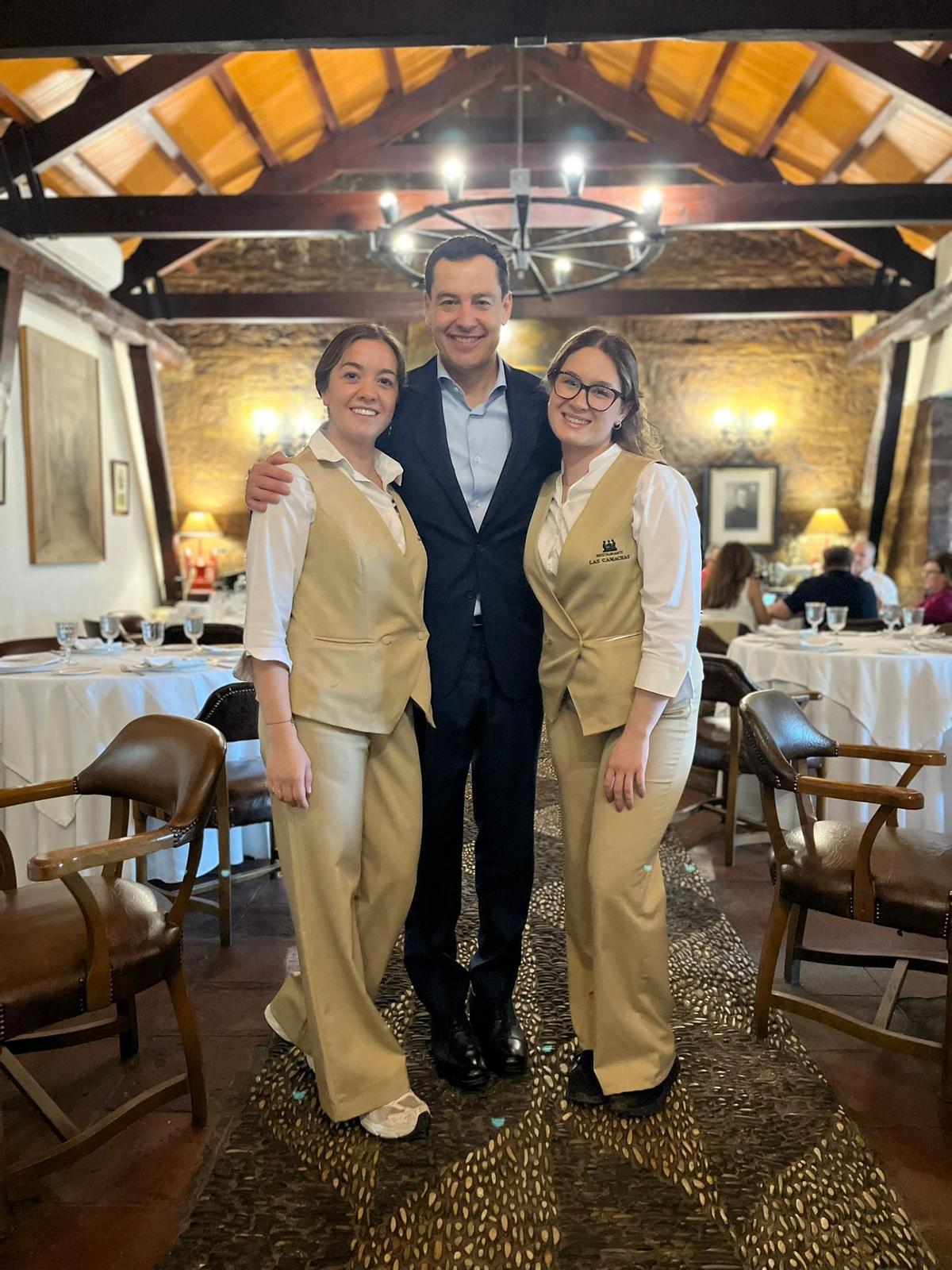 Juanma Moreno, con dos empleadas de Las Camachas, en la foto que compartió el restaurante en sus redes sociales.