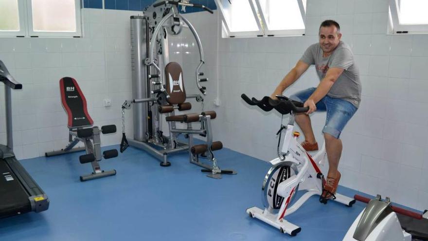 El edil de Deportes, Santiago González Pulido, prueba uno de los aparatos en el gimnasio de Soto del Barco.