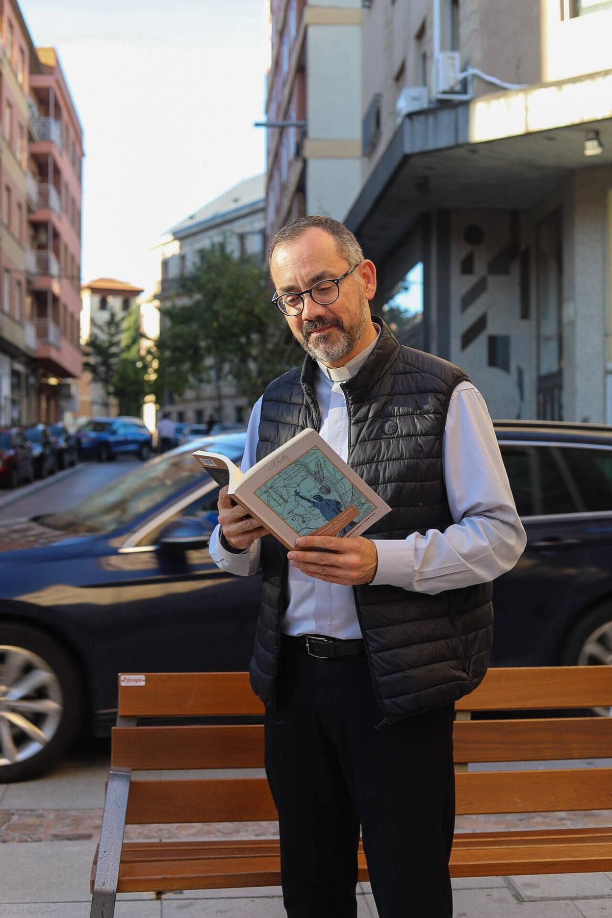 Miguel Ángel Hernández ojea el libro.