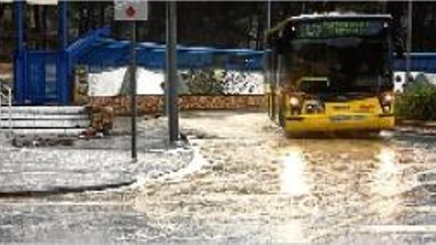 Un bus urbà, en una zona molt afectada per la pluja ahir a Tortosa