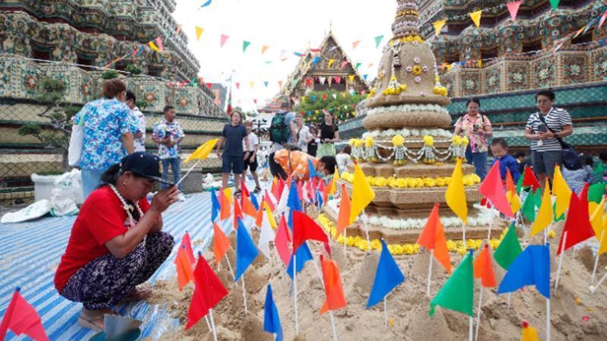 Una mujer reza en presencia de turistas durante la celebración, esta semana, del año nuevo tailandés.