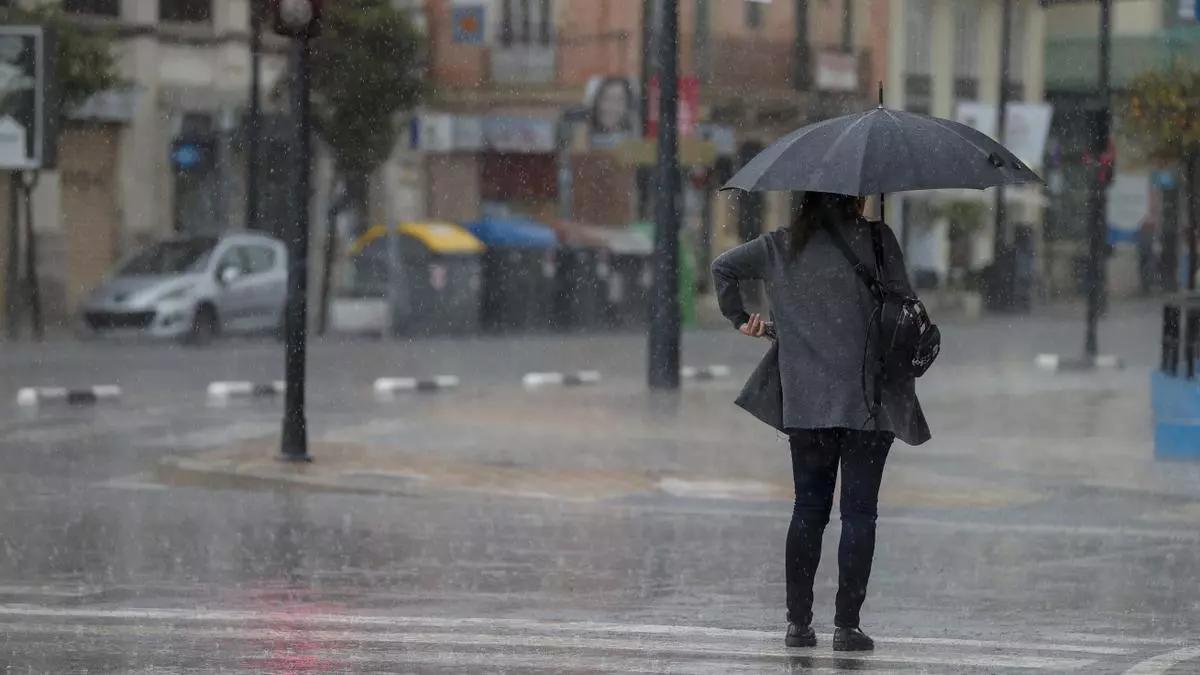 Imagen de archivo de una mujer con su paraguas bajo la lluvia.