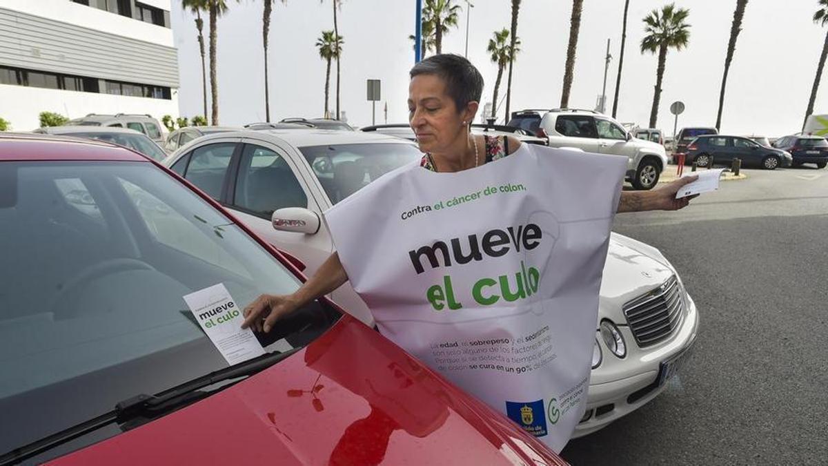 Una voluntaria repartiendo el folleto de la campaña 'Mueve el culo' por el Día Mundial para la Prevención del Cáncer de Colon