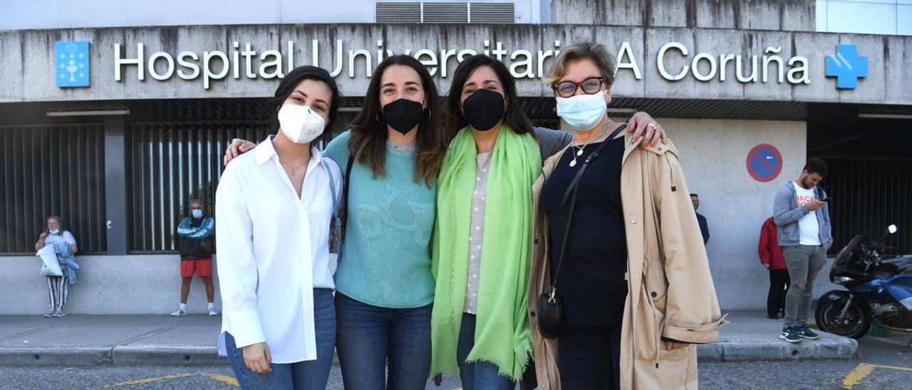 Candela Rodríguez, Marta Corroto y Marisol Jallas, junto a otra voluntaria, María José, delante de la entrada principal del Hospital Universitario de A Coruña.