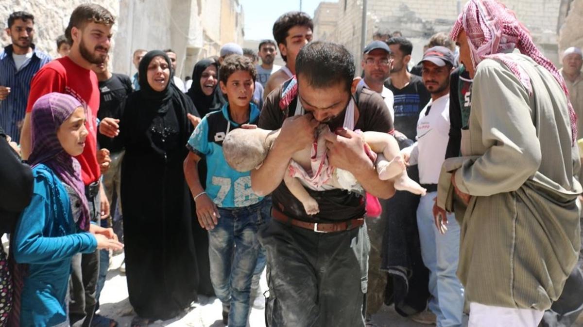 Un hombre sostiene el cuerpo sin vida de su hijo en brazos tras uno de los bombardeos en el barrio rebelde de Al-Marjah, en el norte de Alepo, este domingo.