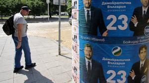 Un hombre pasa junto a un poster electoral del Partido Democrático de Bulgaria, en Sofía.