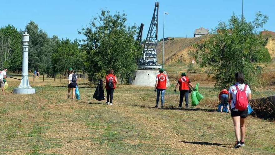 Voluntarios de Cruz Roja recogiendo basura en la zona de la Pradera.