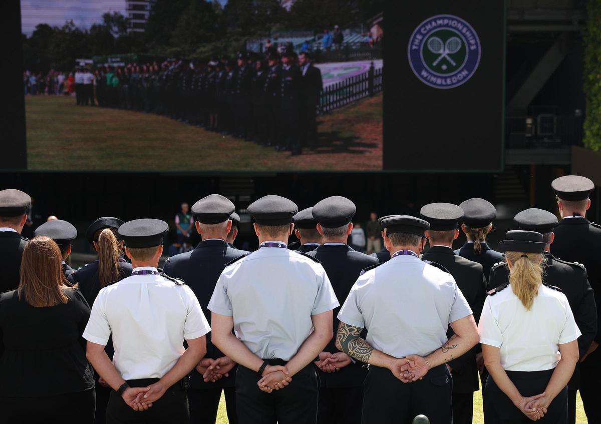 Policías guardan un minuto de silencio por las víctimas de los ataques terroristas del 7 de julio de 2005, este lunes en Wimbledon.
