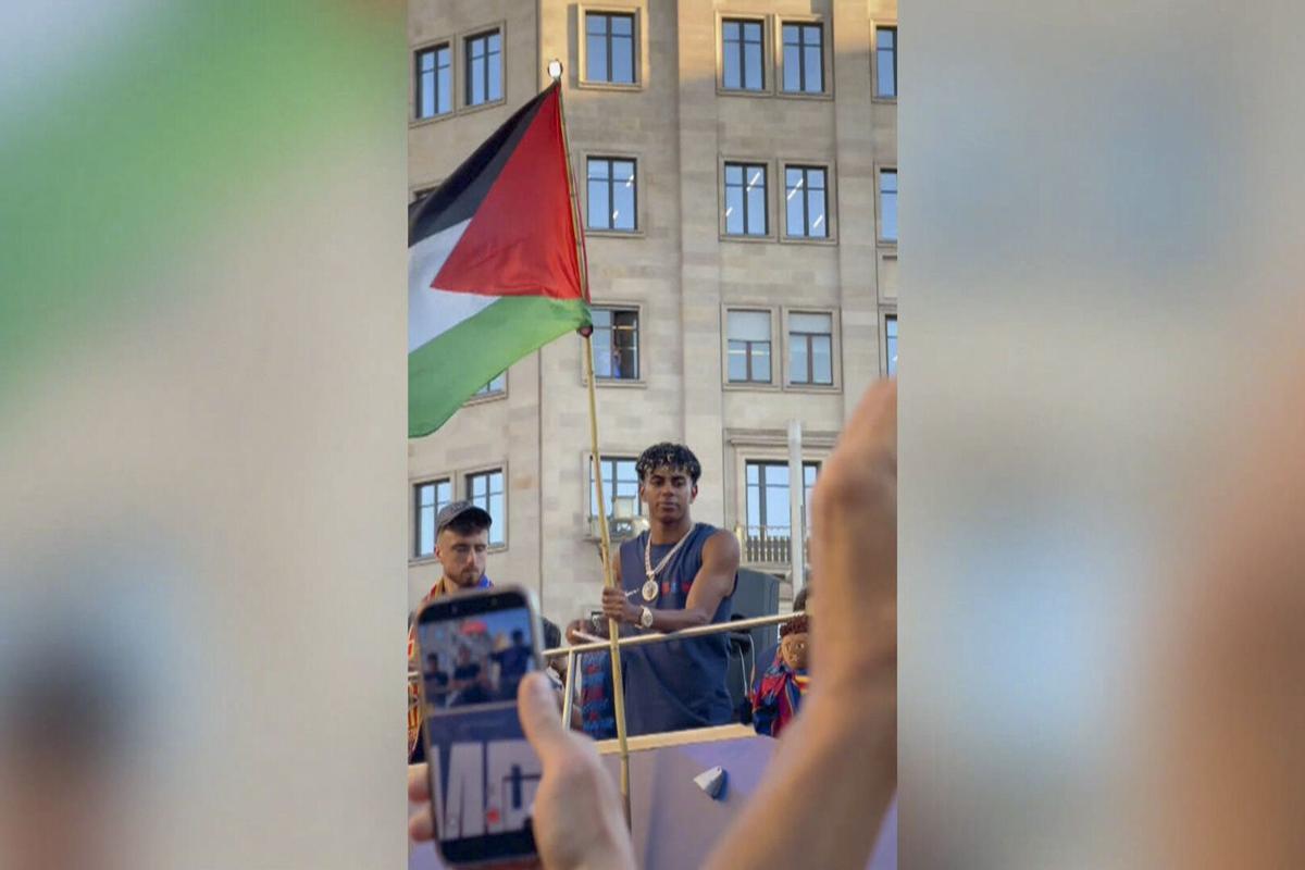 El delantero del Barcelona Lamine Yamal ondeó este lunes una bandera de Palestina durante la rúa de celebración del título de LaLiga, en la que unas 750.000 personas, según la Guardia Urbana, acompañaron al equipo azulgrana por las calles de la capital catalana. EFE/videoaficionada @Nuriacamera. SOLO USO EDITORIAL/SOLO DISPONIBLE PARA ILUSTRAR LA NOTICIA QUE ACOMPAÑA (CRÉDITO OBLIGATORIO)