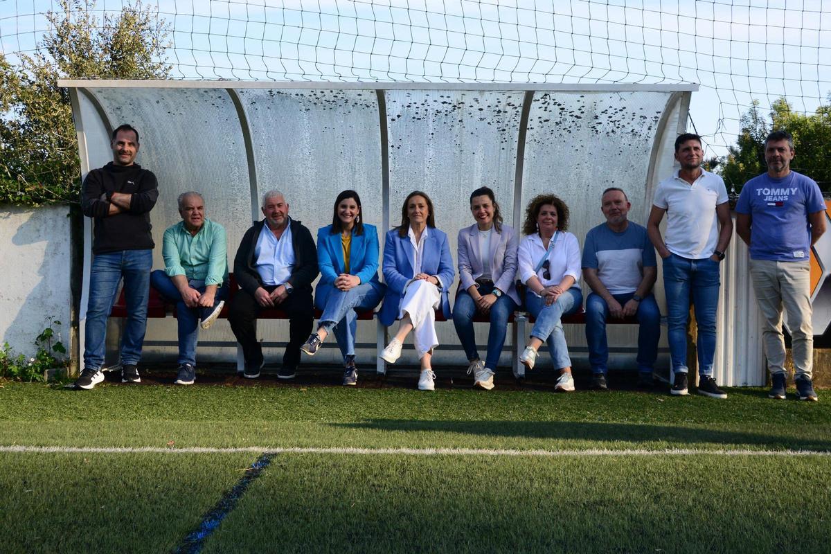 La diputada (centro), alcaldesa (derecha) y ediles en el campo de fútbol de Domaio.
