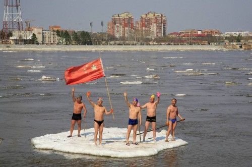 Nadadores saludan desde un trozo de hielo en el río Amur (China)