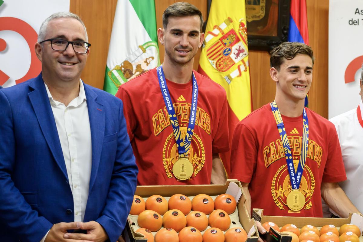 LOS PALACIOS Y VILLAFRANCA (SEVILLA), 21/07/2026. - Los jugadores de la selección española, Gavi (d) y Fabián (c), acompañados por el alcalde de Los Palacios y Villafranca, Juan Manuel Valle, durante la recepción que han recibido este martes en la localidad sevillana. EFE/ Raúl Caro