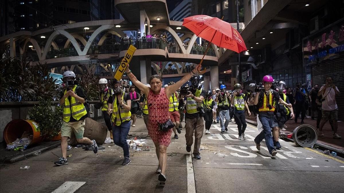 Una mujer sostiene un paraguas, símbolo de la protesta de Hong Kong, durante las manifestaciones en el distrito de Causeway Bay, el 1 de octubre del 2019.