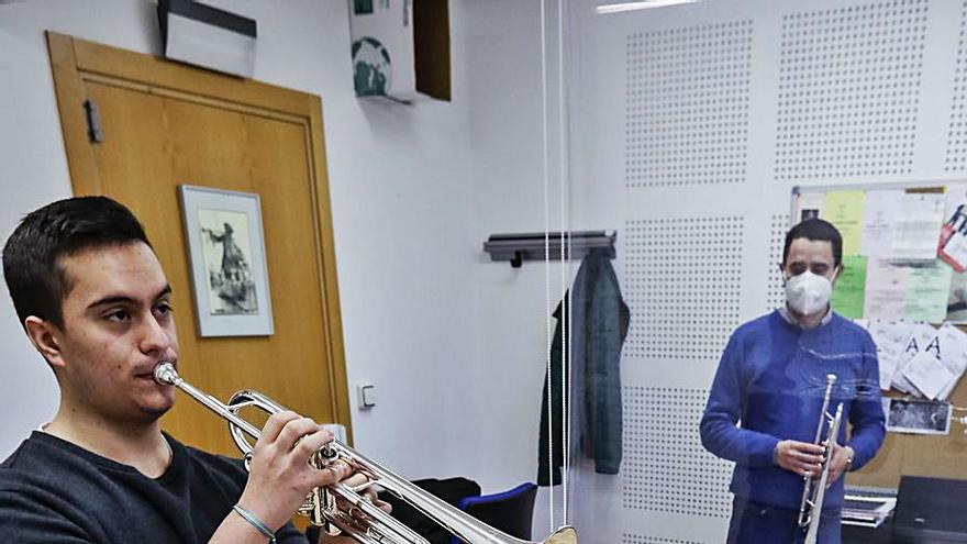 Pablo Núñez ensaya a la trompeta con Gabriel Menéndez, tras una cortina.