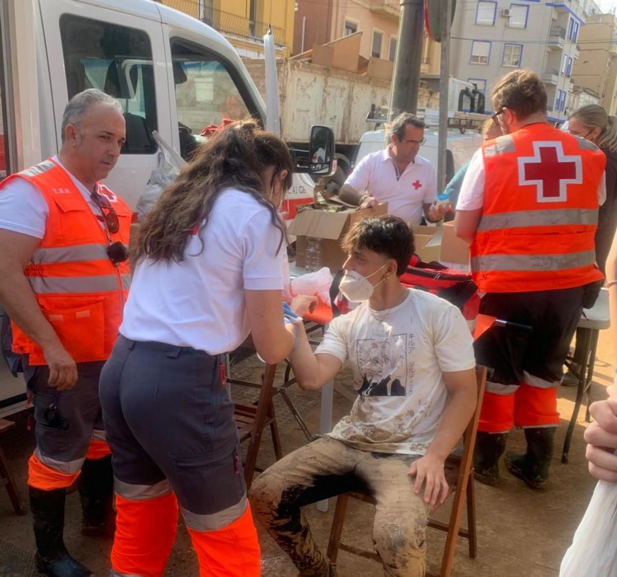 En el corazón de la dana | A LA IZQUIERDA, MIEMBROS DE CRUZ ROJA CÓRDOBA ASISTEN A UN VOLUNTARIO HERIDO DURANTE LAS TAREAS DE LIMPIEZA. A LA DERECHA, CORDOBESES DEJAN EN EL PARQUE DE BOMBEROS ALIMENTOS Y ENSERES DE LIMPIEZA PARA VALENCIA.