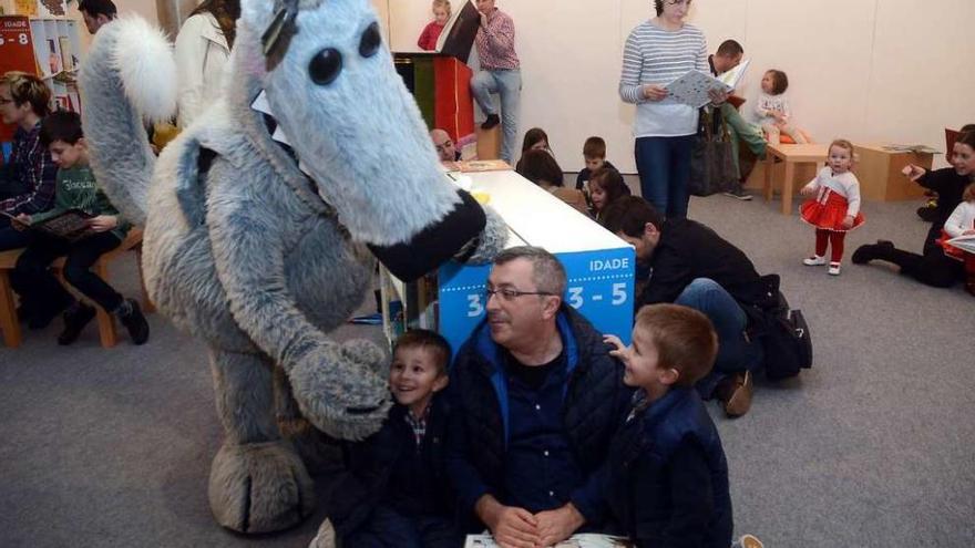 O lobo Orbil, mascota do salón, saúda a unha familia. // Rafa Vázquez