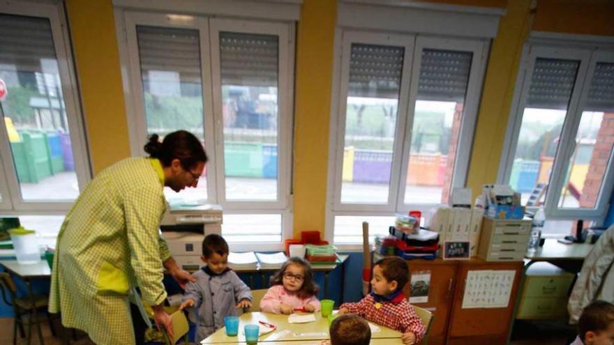 Los niños de la escuela de Gudín se disponen a desayunar ante la mirada del director del centro, Berto García.