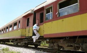Una dona puja a un tren en marxa a Albània.