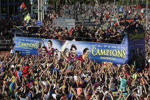 Gairebé un milió de persones van sortir al carrer per seguir la rua dels campions de la Lliga i d’Europa. En la imatge,  el pas del bus dels jugadors per la plaça de Colom.