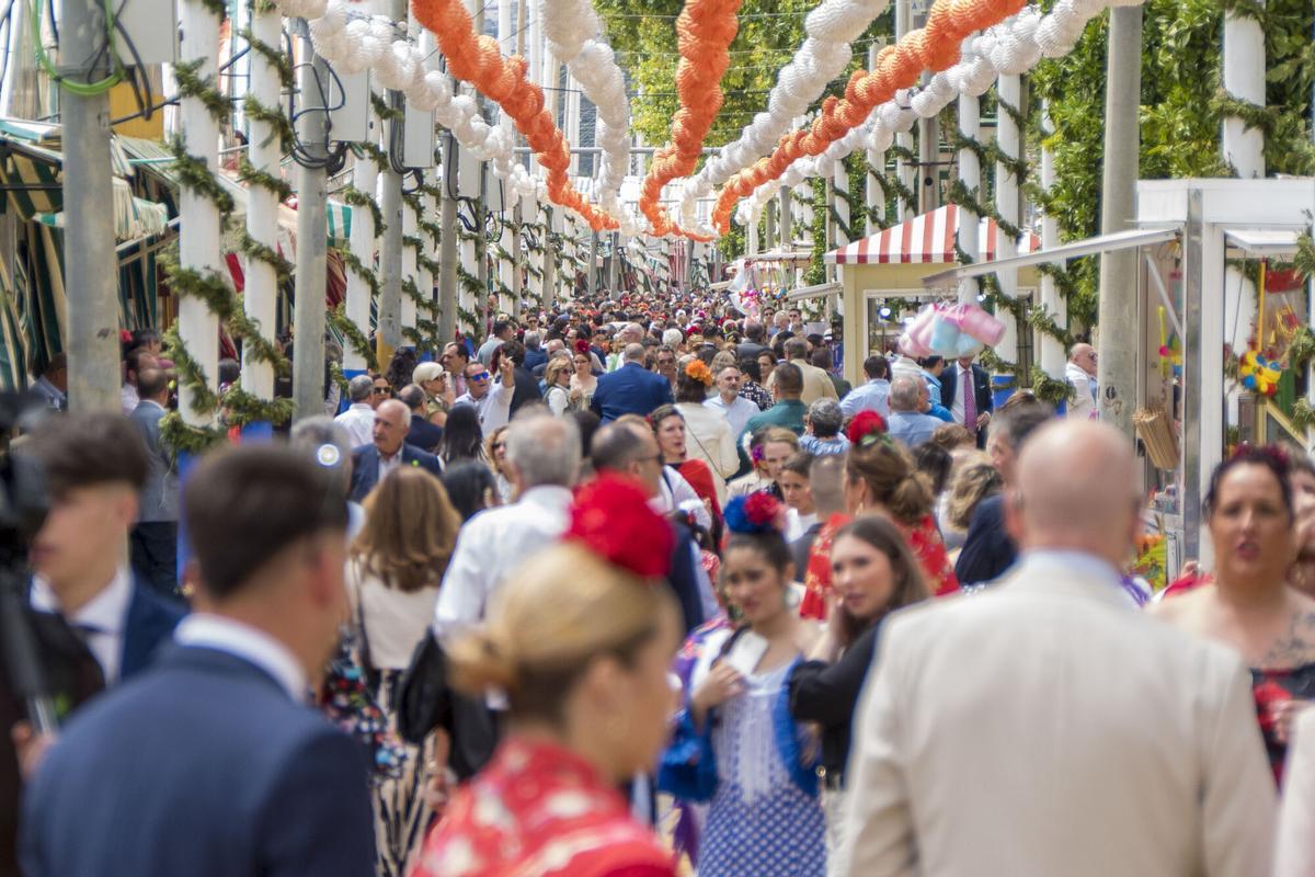 Cientos de personas pasean por el Real de la Feria de Abril de Sevilla.