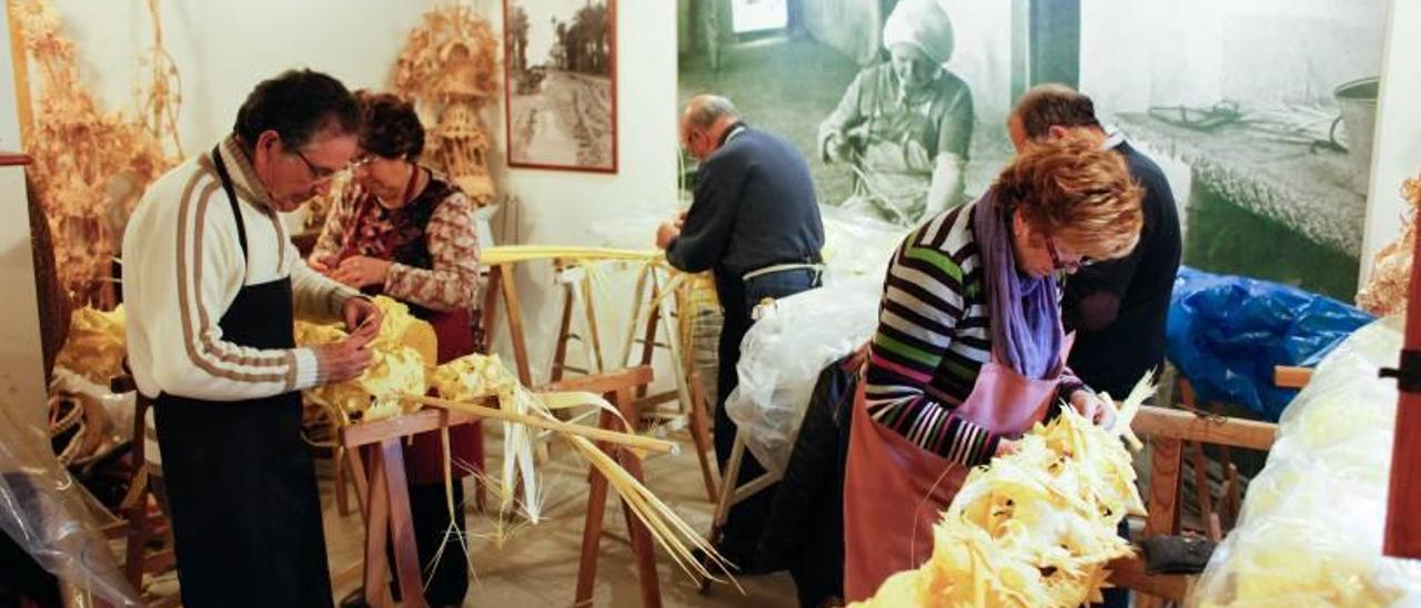 Ilicitanos en el taller de palma blanca del Huerto de San Plácido.