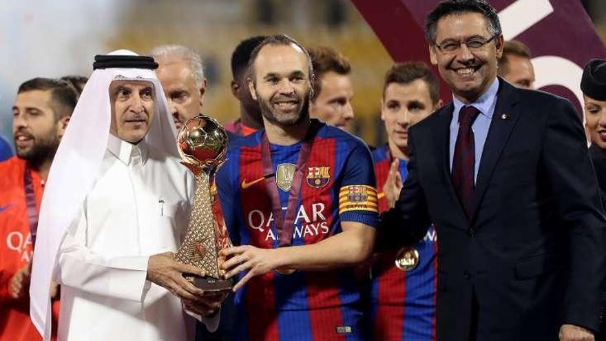 Iniesta sostiene el trofeo de ganador. // Reuters