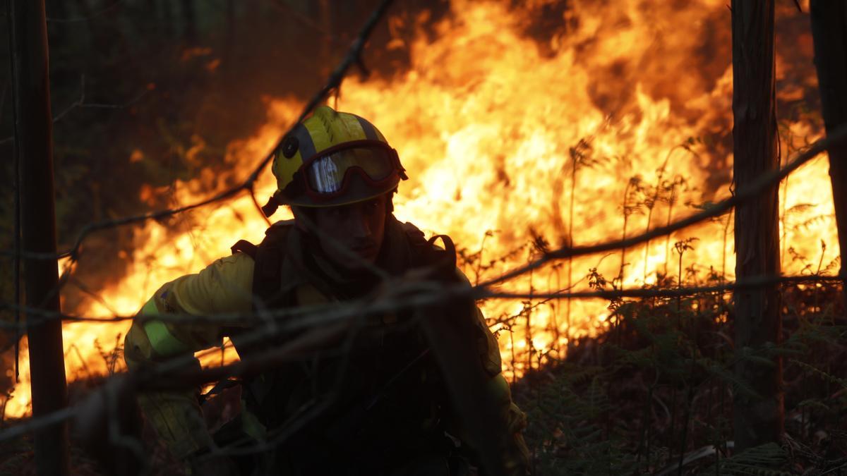 Los bomberos usan contrafuegos para evitar que las llamas lleguen a las viviendas en Tineo