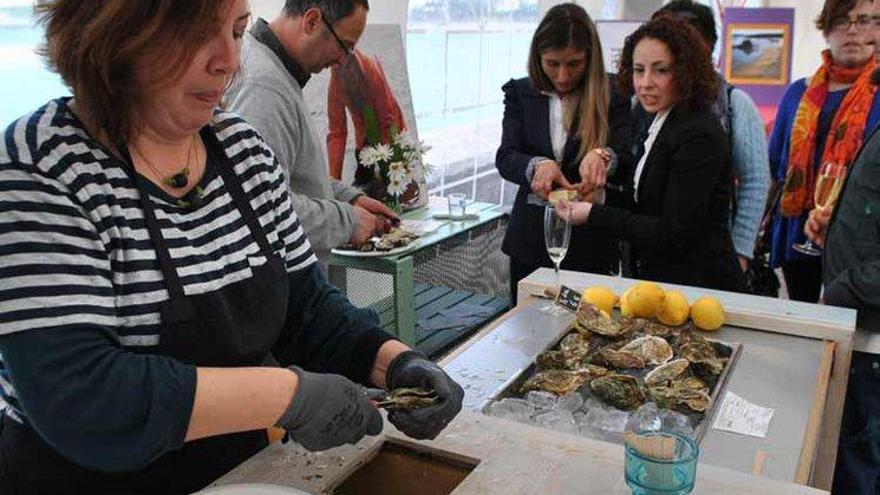 En primer término, Nuria Núñez abriendo ostras, ayer, en Castropol.