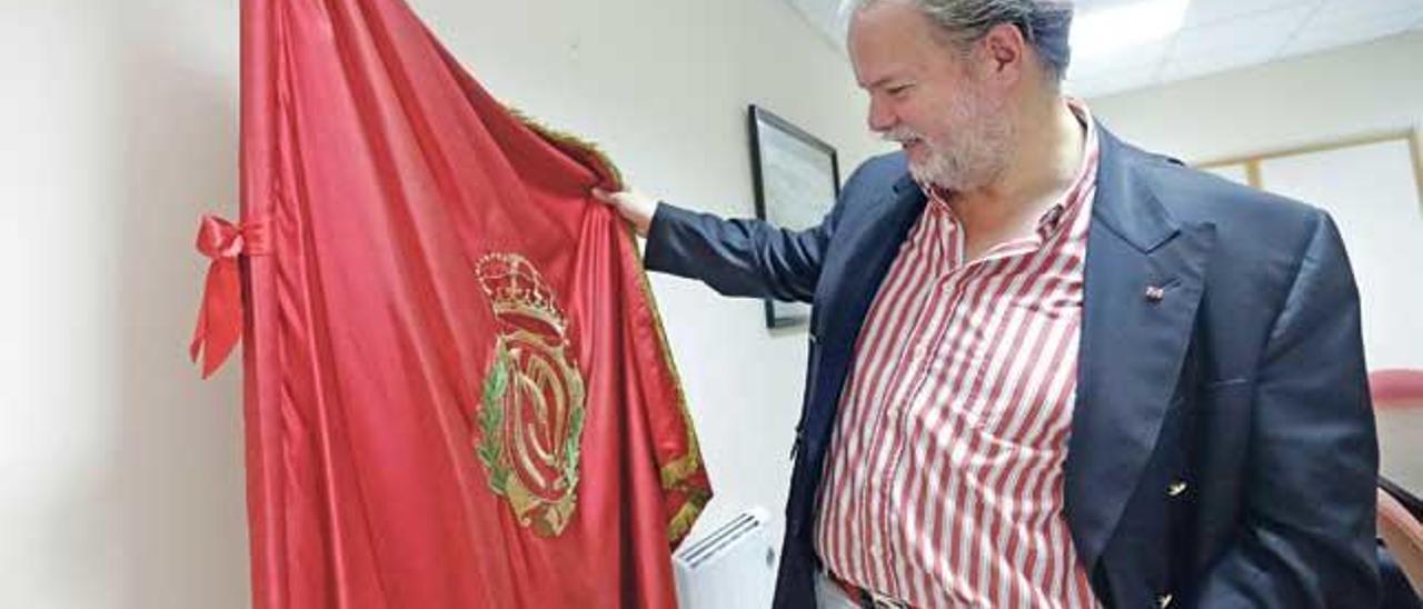 Claassen sostiene la bandera del Mallorca en su despacho.