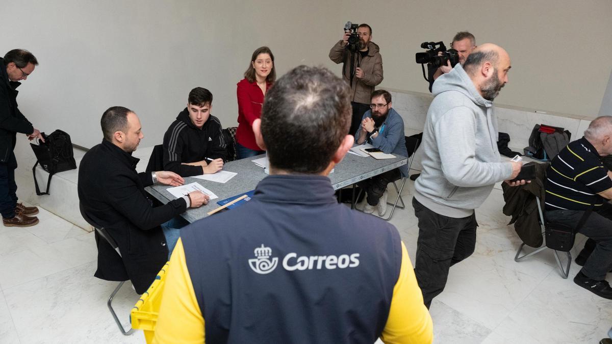Un trabajador de Correos lleva los votos realizados por correo a la mesa electoral en una imagen de achivo
