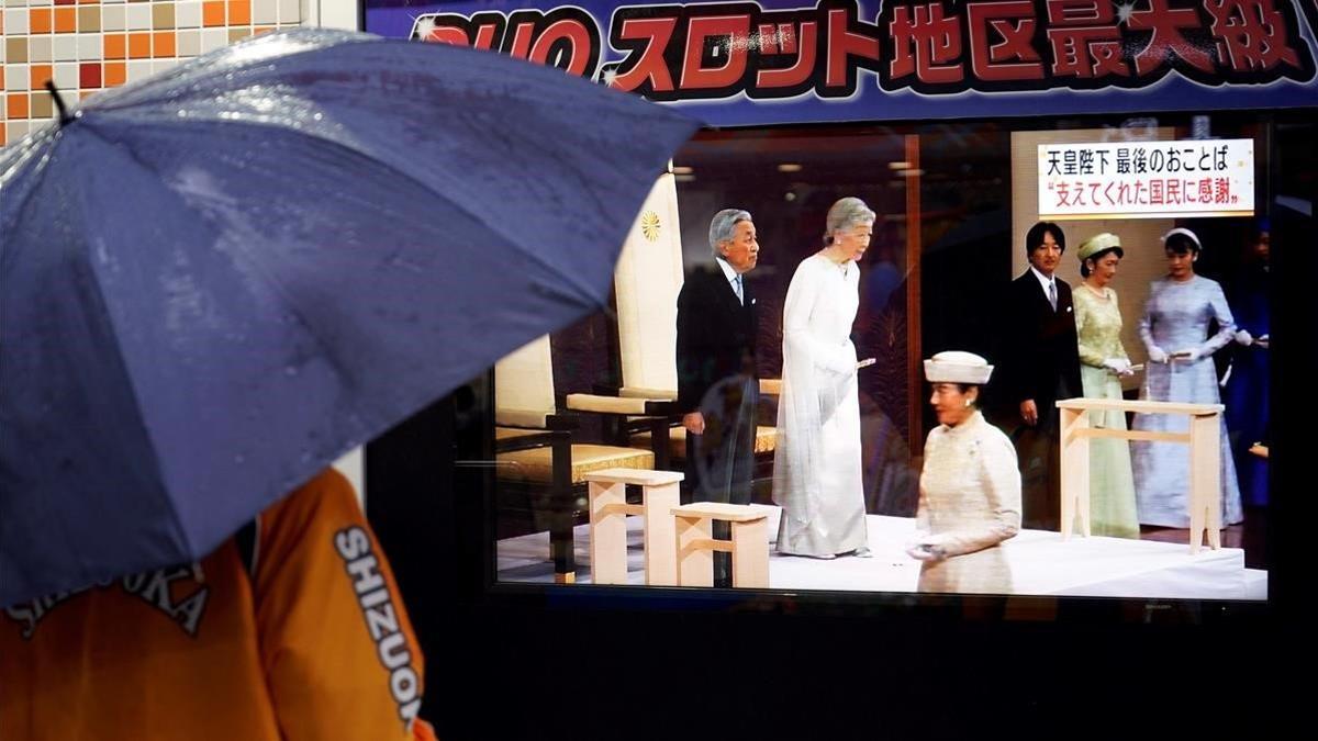 Una mujer sigue por televisión la ceremonia de abdicación de Akihito, este martes en Tokio.